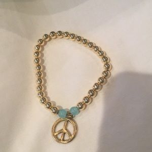NWOT Gold ball bracelet with peace sign charm.
